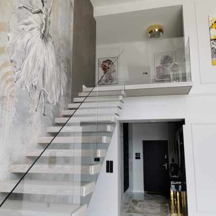 Schody półkowe z balustradą szklaną